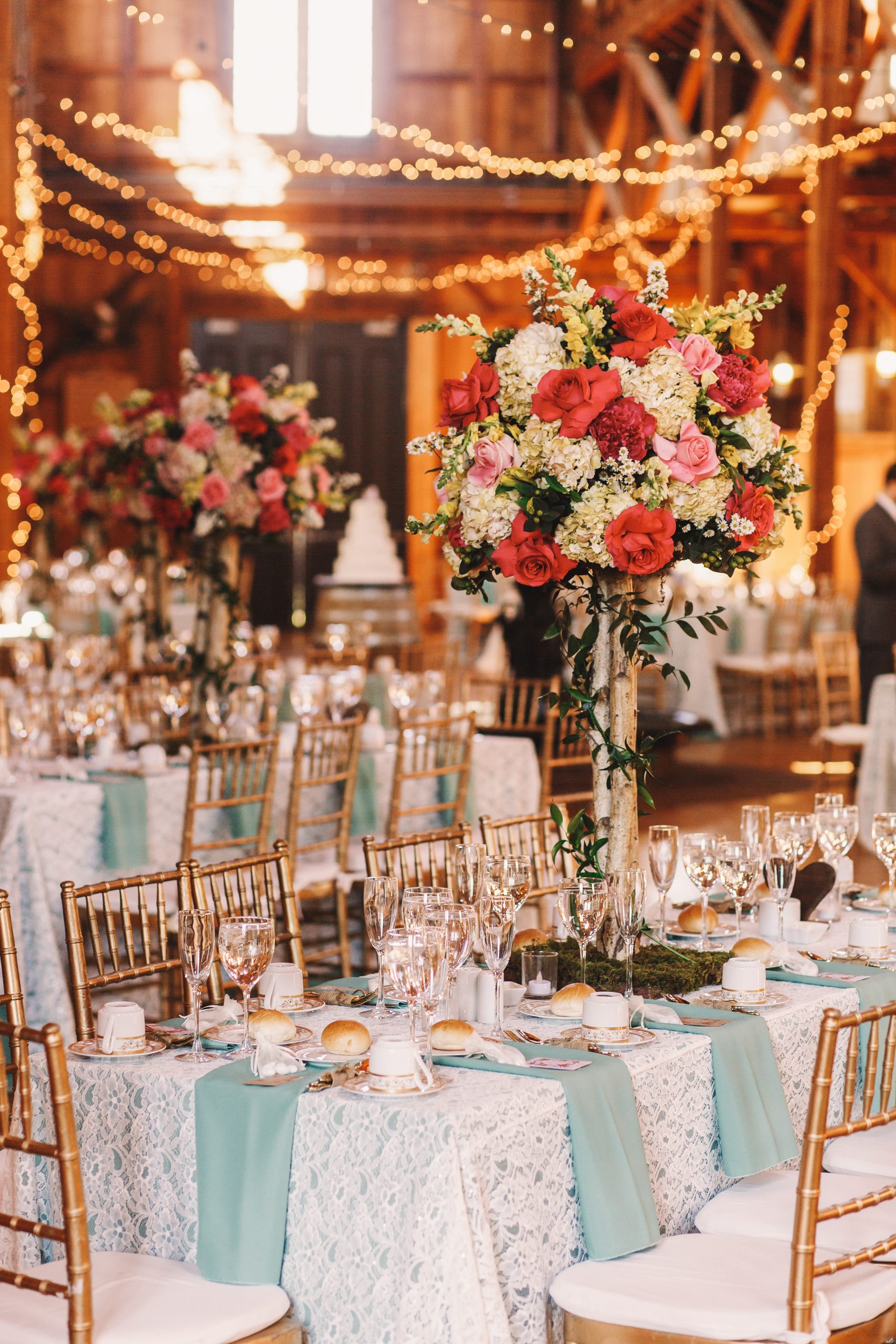 Yellow light garlands hang over the dinner tables decorated with