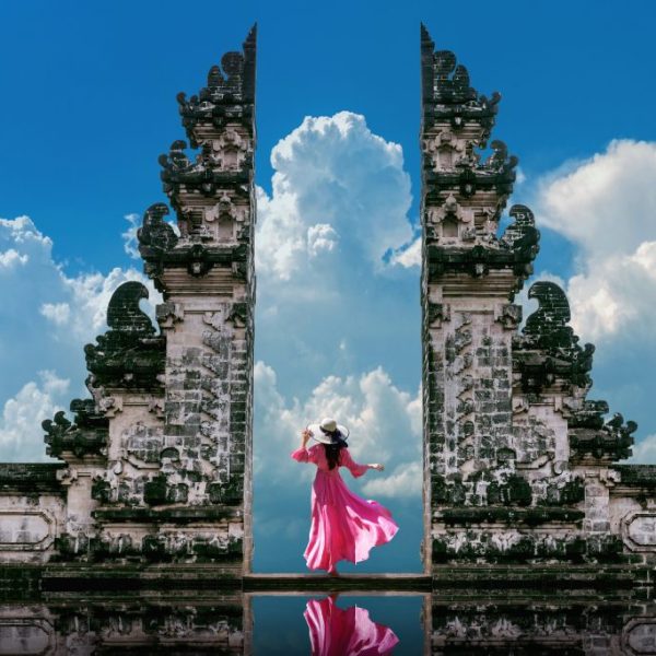 Young woman standing in temple gates at Lempuyang Luhur temple i